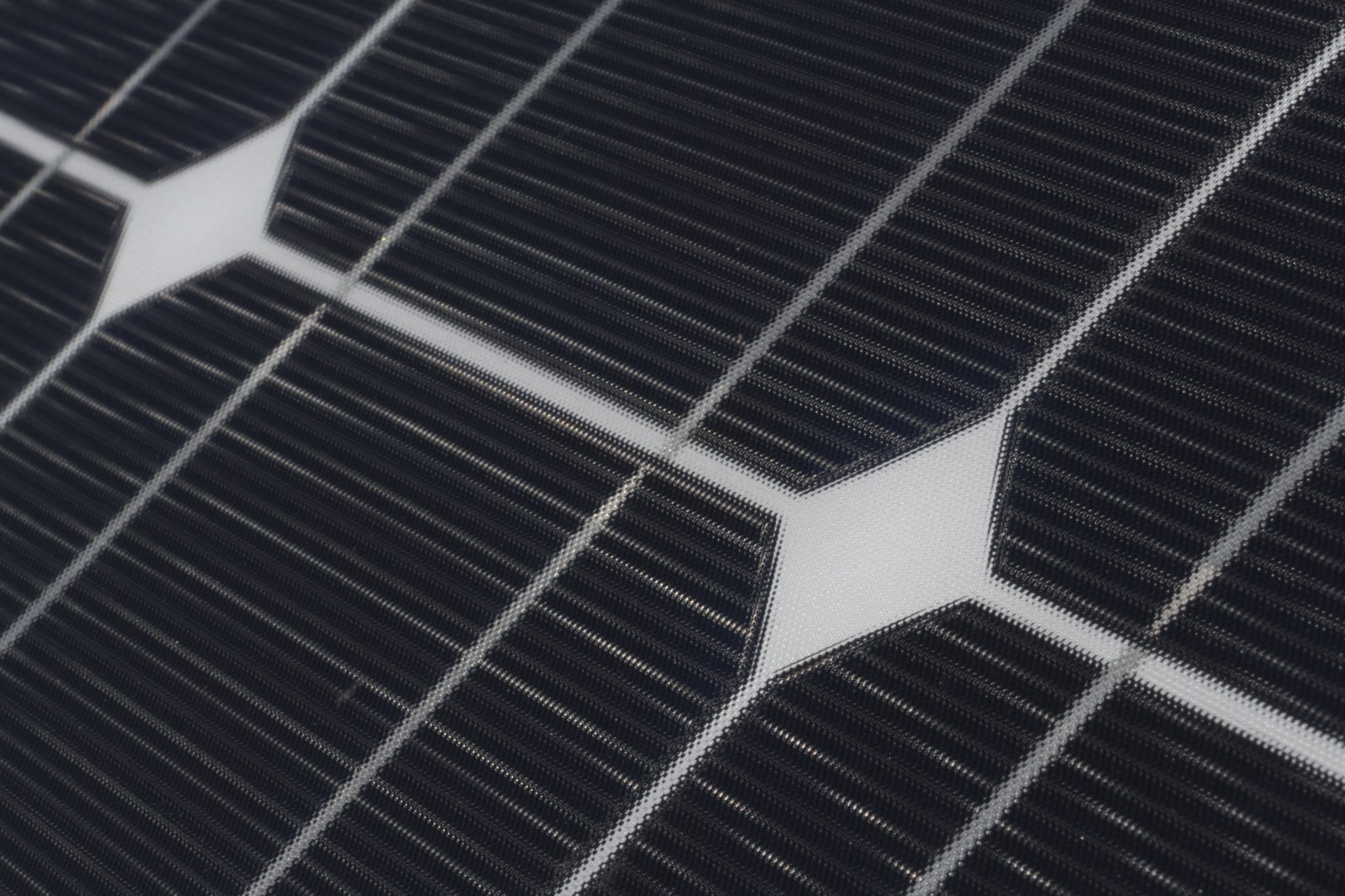 Close-up of the silver bus lines on dark monocrystalline solar cells